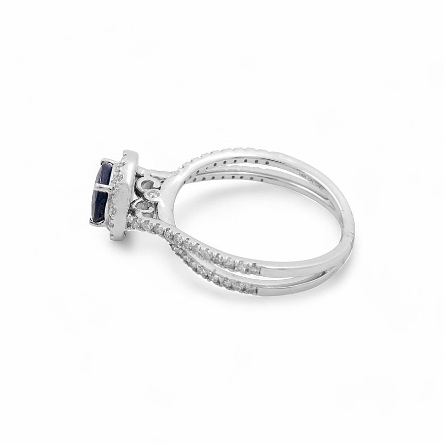 The Miral Jewelry 14K White Gold Woman Fashion Ring with Diamonds and Sapphire features a stunning rectangular blue gemstone set among small clear diamonds embedded in the band, making it an exquisite piece.
