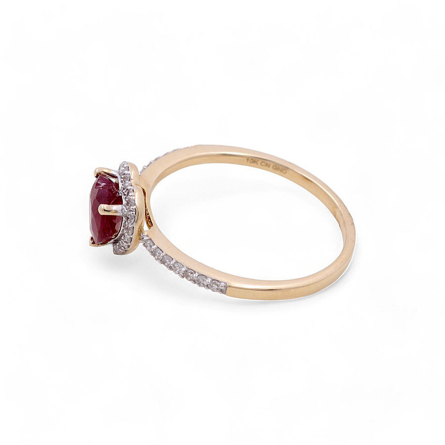 The 14K Yellow Gold Woman Fashion Ring by Miral Jewelry features a heart-shaped ruby at its center, encircled by small diamonds and further adorned with additional diamonds along the band.