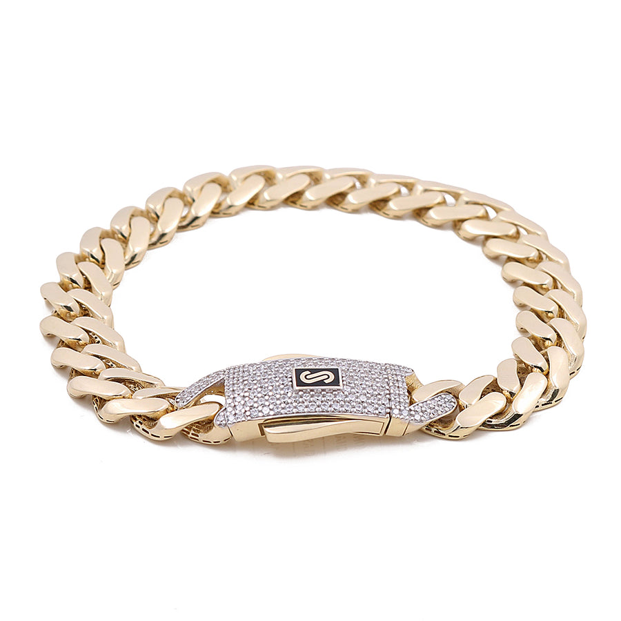 The Monaco Bracelet by Miral Jewelry, crafted in 14K Yellow Gold, showcases a central clasp adorned with diamonds and a monogrammed "S," embodying luxury.