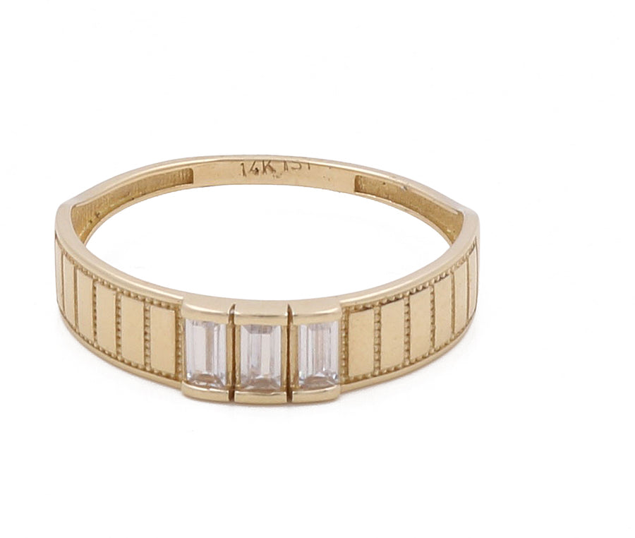 The 14K Yellow Gold Men Wedding Ring with Zirconias by Miral Jewelry features three rectangular-cut zirconias set in a row on its band, making it the perfect sophisticated men's wedding ring.