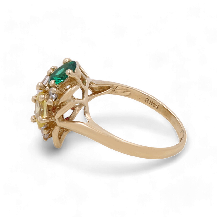 The 14K Yellow Gold Fashion Women's Ring with Stones by Miral Jewelry features a central green gemstone framed by sparkling stones, all set in a band marked with 14K B, radiating elegance.