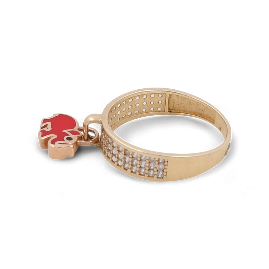 Introducing the 14K Yellow Gold Red Elephant Fashion Women Ring with Zirconia by Miral Jewelry — a stunning gold ring adorned with a row of small, clear zirconia stones on the band and a charming red enamel elephant charm.