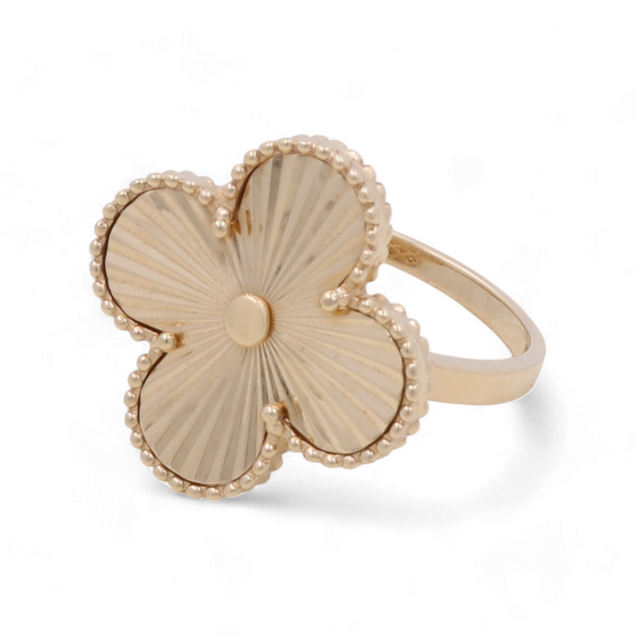 The Miral Jewelry 14K Yellow Gold Fashion Flower Women's Ring features a clover-shaped design with textured petals and a beaded border, making it the perfect accessory for any Sweet Fifteen celebration.