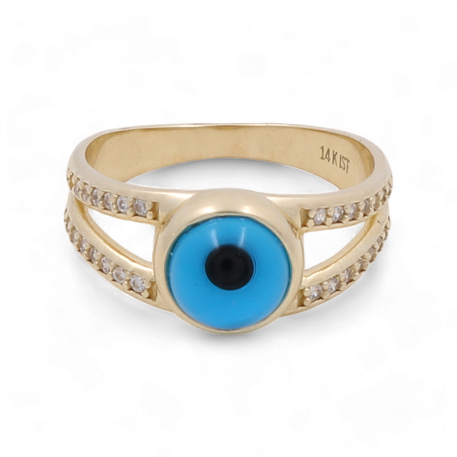 The 14K Yellow Gold Fashion Evil Eye with Zirconias Women's Ring by Miral Jewelry features a centered blue and black evil eye design, flanked by two rows of small clear stones on either side. This stunning ring combines elegance and protection in one exquisite piece.