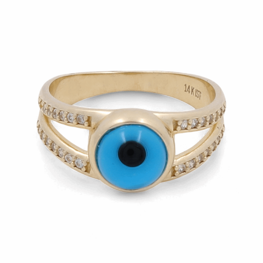 The 14K Yellow Gold Fashion Evil Eye with Zirconias Women's Ring by Miral Jewelry features a centered blue and black evil eye design, flanked by two rows of small clear stones on either side. This stunning ring combines elegance and protection in one exquisite piece.