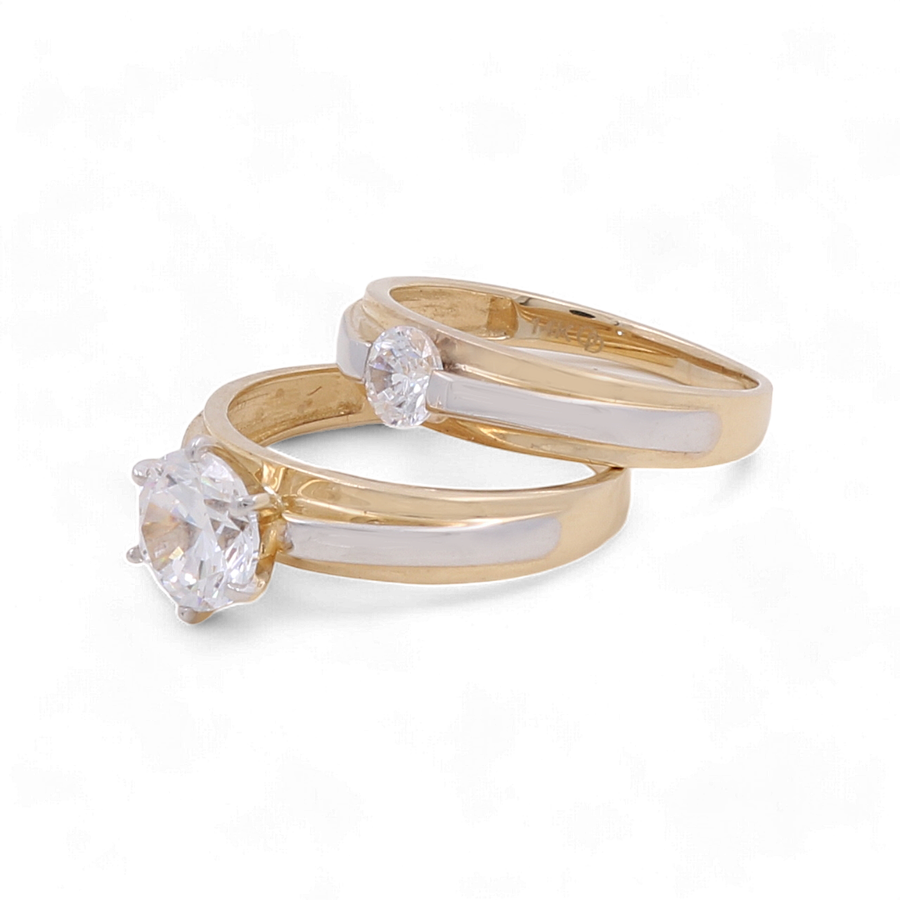 Miral Jewelry offers a stunning 14K Yellow Gold Bridal Women's Ring set, featuring one ring with a large round diamond and another adorned with a smaller round zirconia, both elegantly enhanced with white inlay.