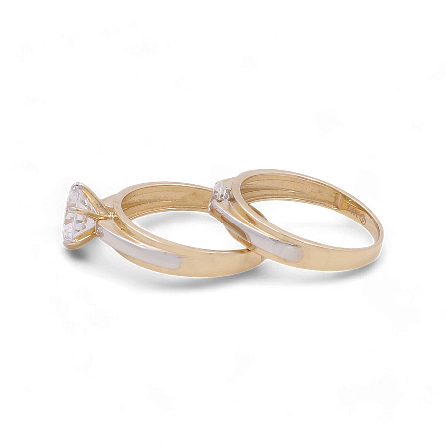 Two 14K Yellow Gold Bridal Women's Rings with clear zirconia gemstones from Miral Jewelry, placed next to each other on a white background. This elegant pairing is perfect for a bridal women's ring set.