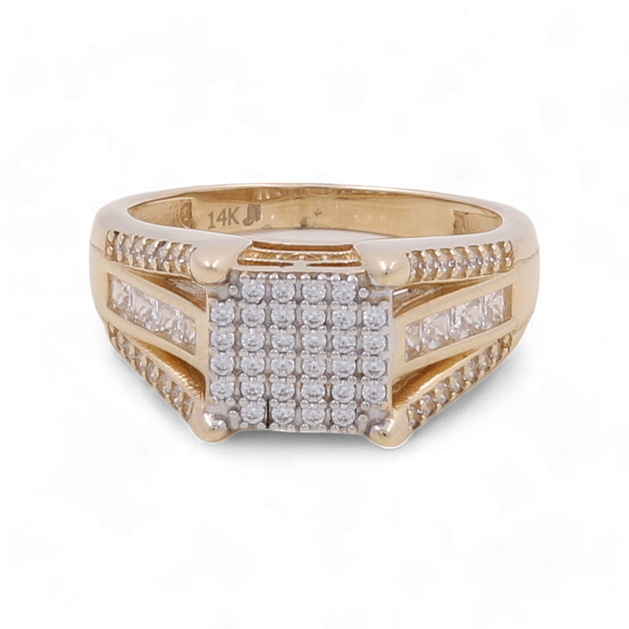 Behold the 14K Yellow Gold Wedding Men's Ring by Miral Jewelry, featuring a luxurious gold band with a square-shaped design on top. It is encrusted with numerous small zirconia stones and additional zirconia set along the sides. The inside band is exquisitely engraved with "14K," making it an impeccable choice for a wedding ring.