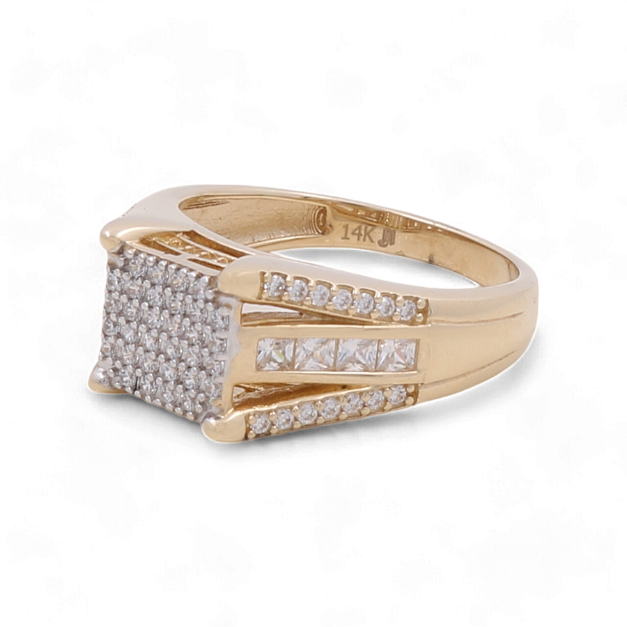 The Miral Jewelry 14K Yellow Gold Wedding Men's Ring with Zirconia is a luxurious piece that showcases a large rectangular cluster of zirconia on top, complemented by additional zirconia stones set along the 14K yellow gold band.