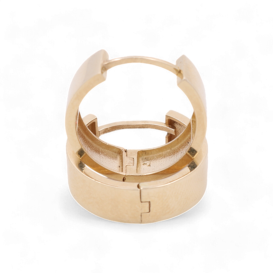 A 14K yellow gold cuff bracelet with a hinged clasp, viewed from an elevated angle against a white background, perfectly complements any pair of Miral Jewelry's 14K Yellow Gold Fashion Hoop Women's Earrings.