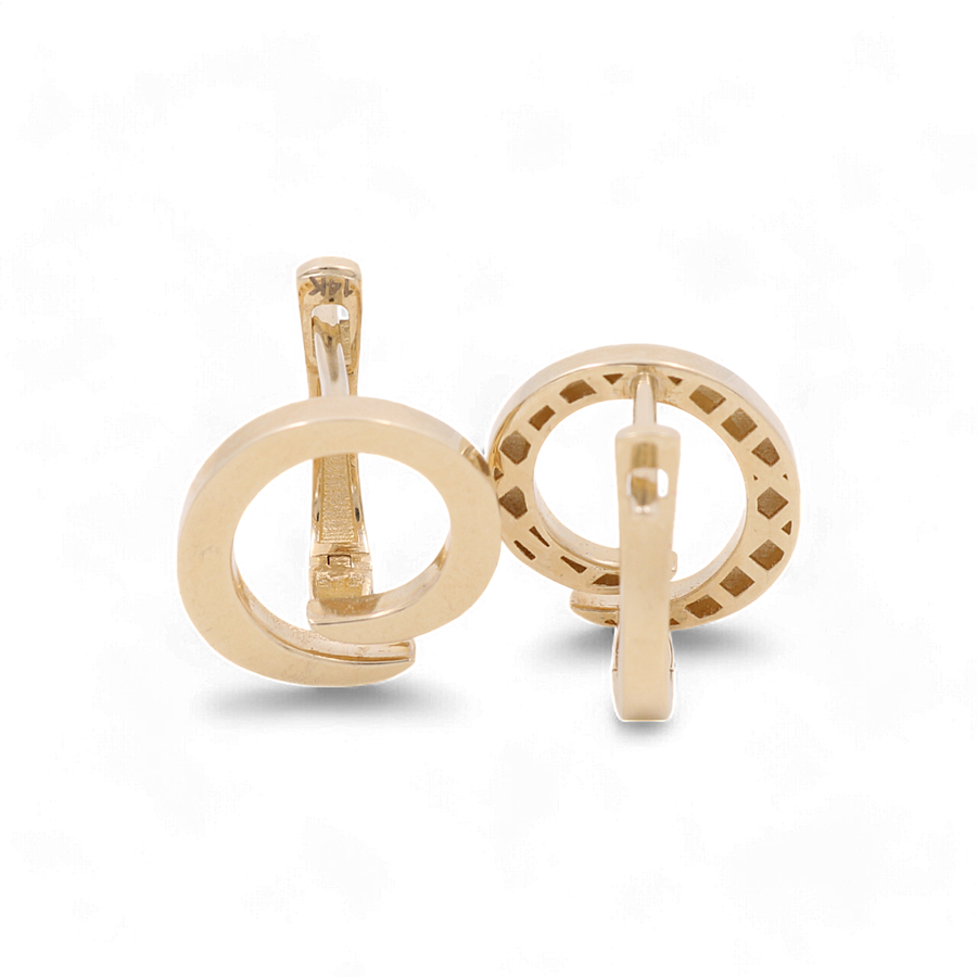 A pair of gold circular cufflinks, one featuring a solid design and the other with a perforated border, reminiscent of the elegance found in Miral Jewelry's 14K Yellow Gold Omega Back Women's Earrings.