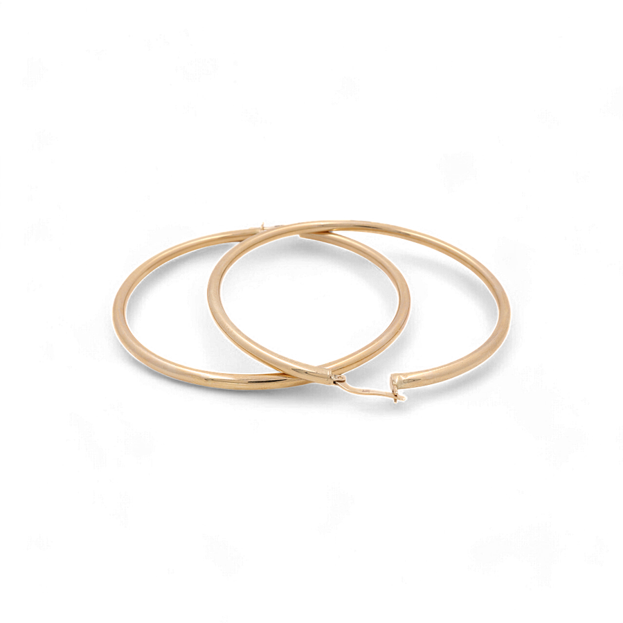 Two elegant hoop earrings by Miral Jewelry, crafted from 14K yellow gold with a simple and smooth design, placed next to each other on a plain white background.