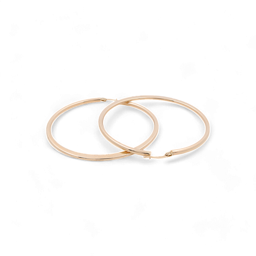 Two 14K Yellow Gold Large Hoop Women's Earrings by Miral Jewelry are placed overlapping on a plain white background, epitomizing elegance in women's accessories.