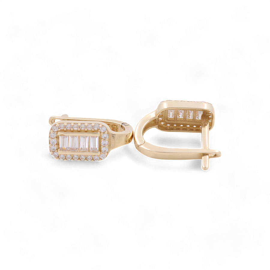 A pair of Miral Jewelry 14K Yellow Gold Huggie Women's Earrings adorned with cubic zirconia gemstones on a white background.