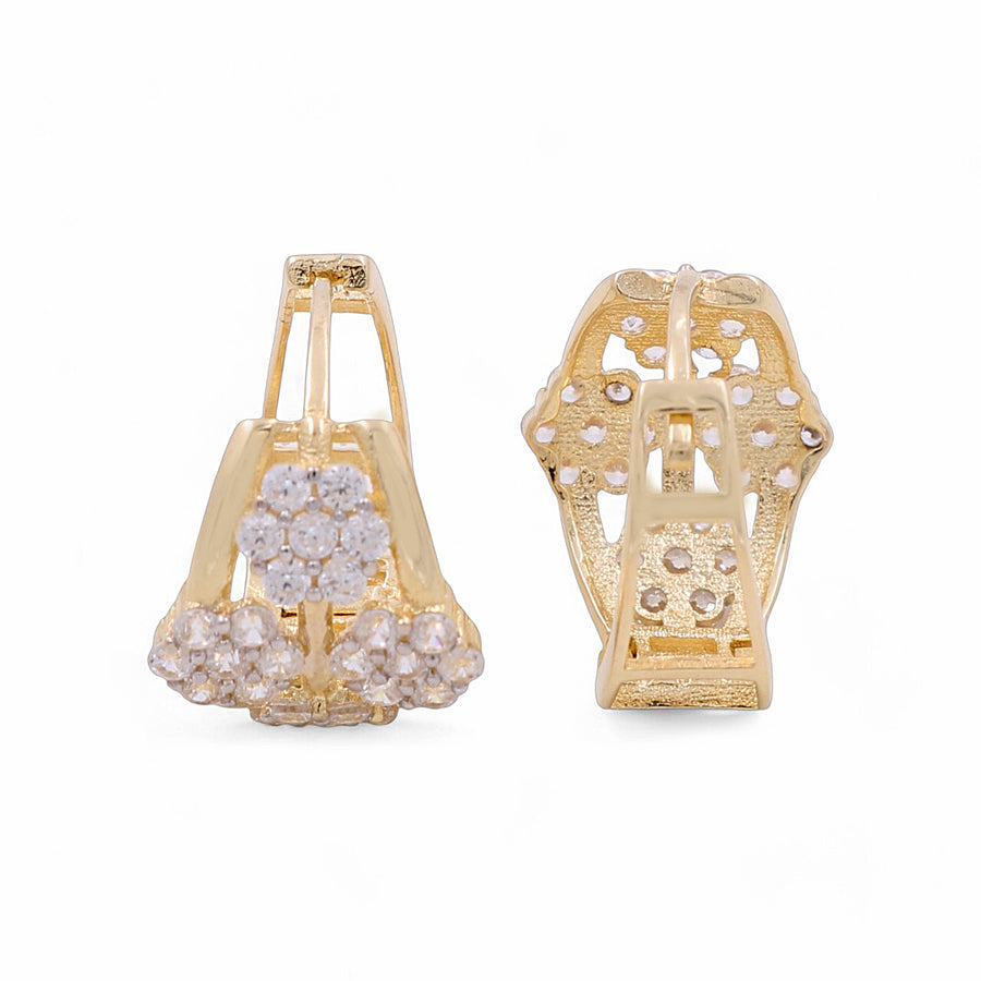 A pair of Miral Jewelry's 14K Yellow Gold Huggie Women's Earrings, adorned with a cluster of small, white stones arranged in an elegant floral pattern.