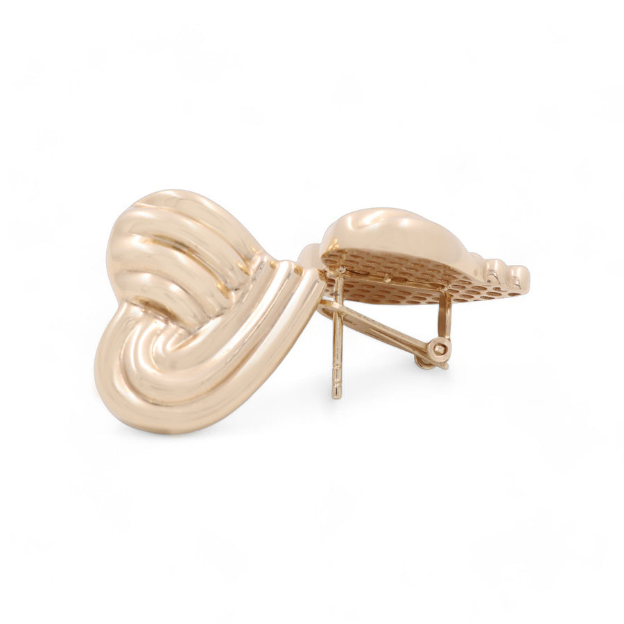 A gold-colored, heart-shaped hair clip with a textured surface and a clasp mechanism, reminiscent of the 14K Yellow Gold Fashion Hearts Women's Earrings by Miral Jewelry.