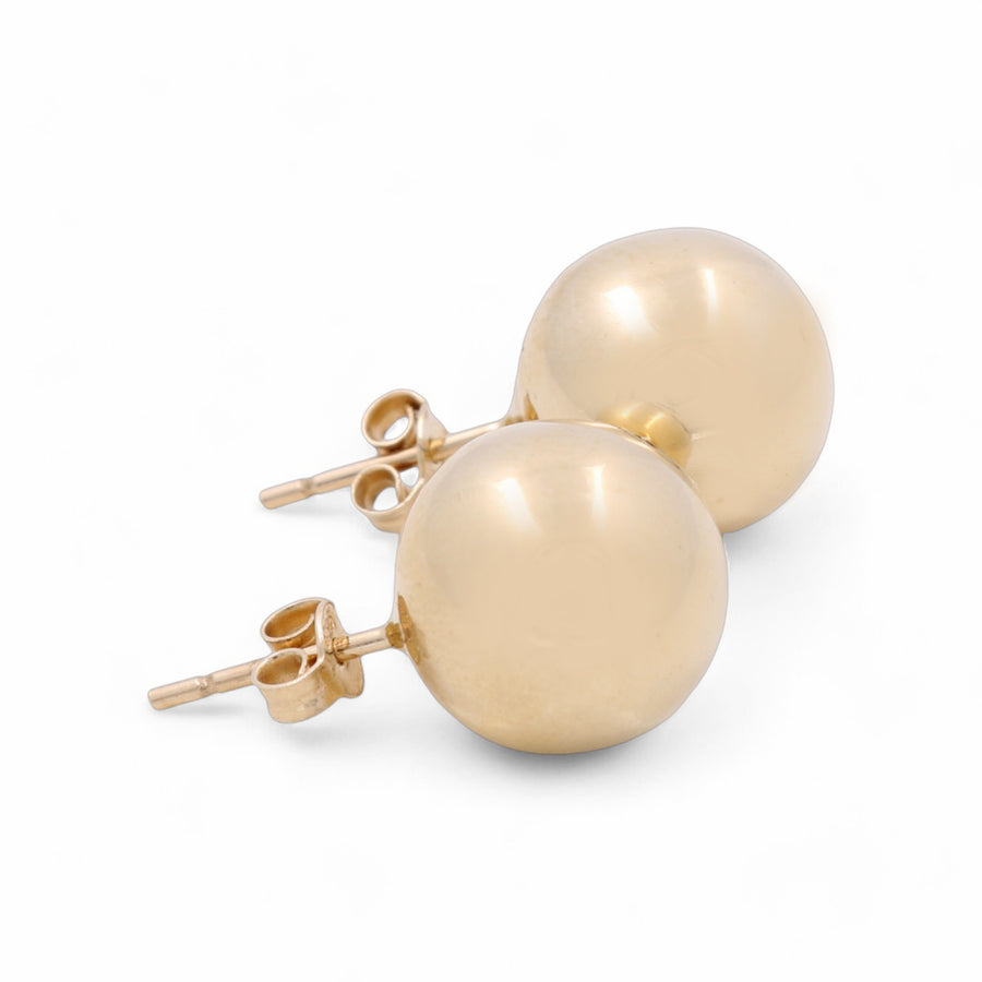 A pair of 14K yellow gold pearl button women's earrings by Miral Jewelry, featuring butterfly backings, elegantly placed on a white background.