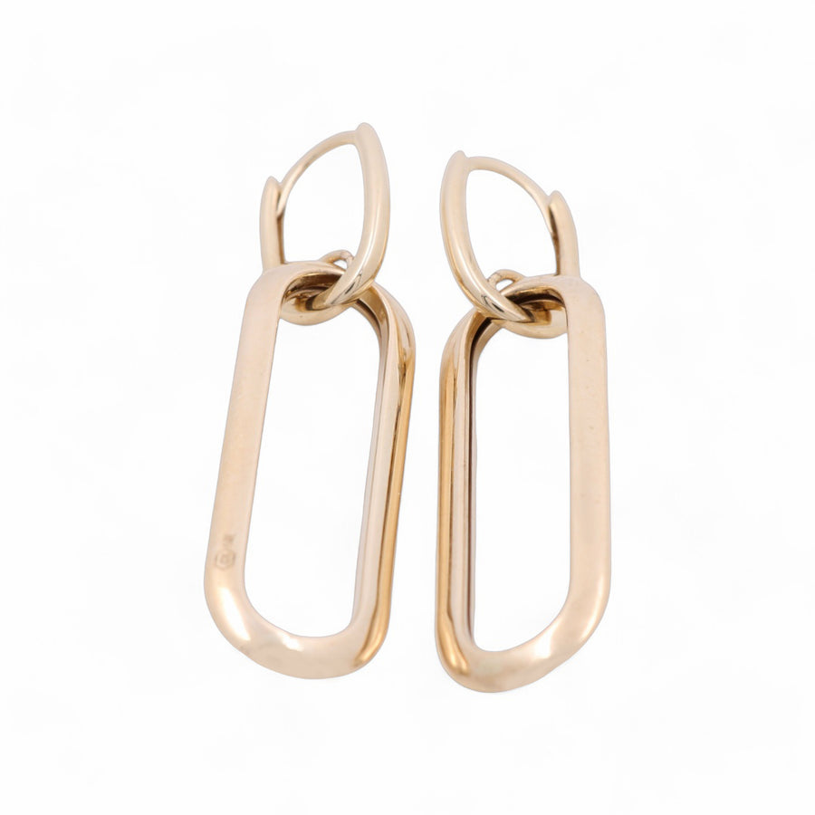 A pair of Miral Jewelry's 14K Yellow Gold Large Hoop Earrings, featuring an elongated rectangular shape and smooth finish, perfect for adding a sophisticated touch to any jewelry collection.