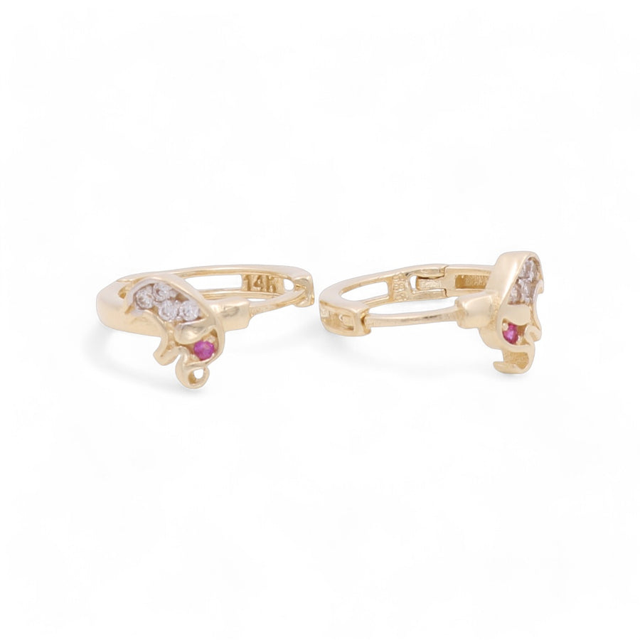 These 14K Yellow Gold Small Hoop Women's Earrings by Miral Jewelry are a stunning pair featuring an elegant dolphin design with embedded diamonds and a single pink stone at the bottom.