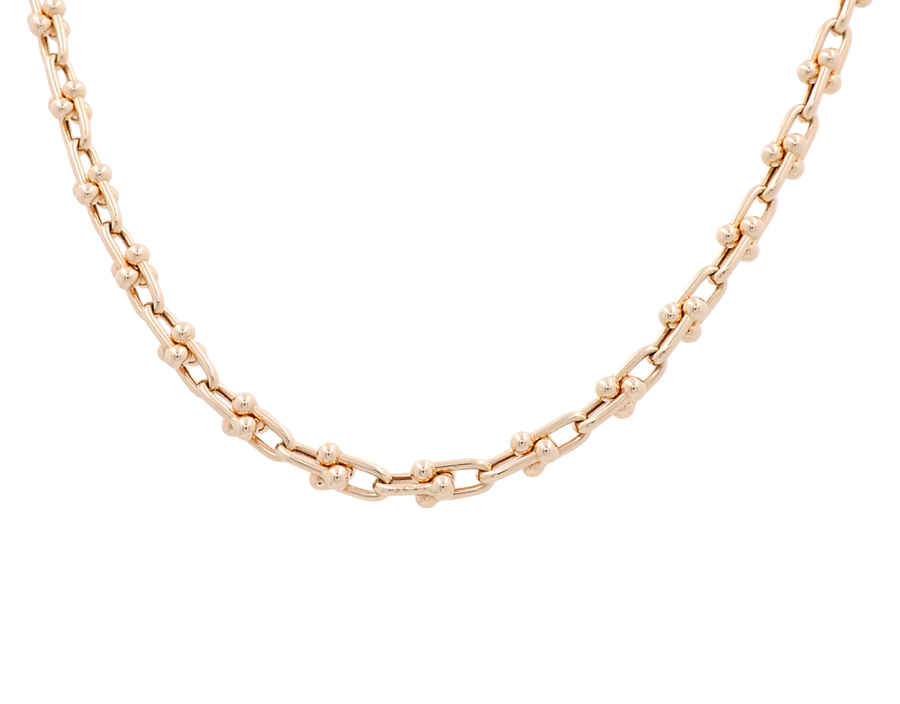 A close-up view of the 14K Yellow Gold Fancy Link Chain by Miral Jewelry, showcasing an elegant design with small bead accents. The necklace features a repeating pattern of larger links separated by smaller beads.