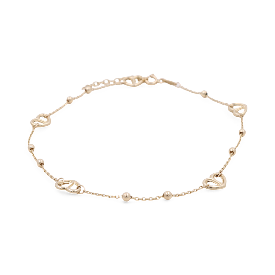 The Miral Jewelry 14K Yellow Fashion Women's Ankle Bracelet is a delicate accessory featuring heart-shaped and small round bead accents, with a simple chain and clasp for a subtle fashion statement.