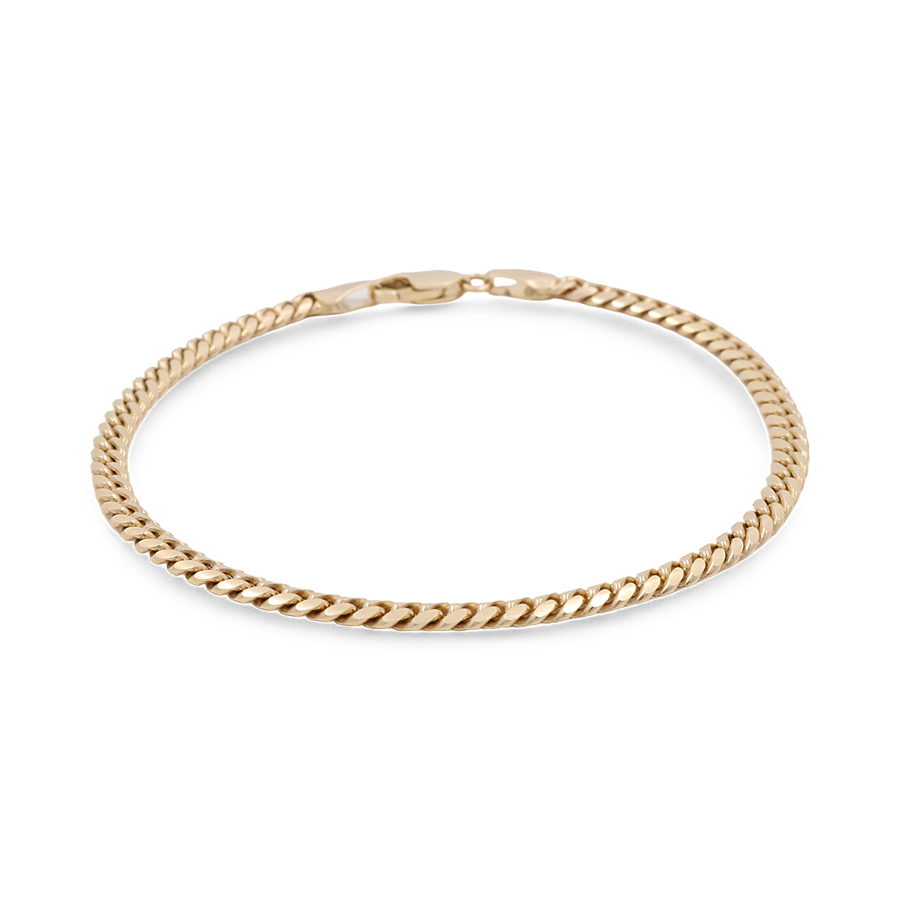 A close-up image of a thin 14K Yellow Gold Women's Fashion Cuban Link Bracelet from Miral Jewelry, featuring a lobster clasp, laid out in a circular shape against a white background.