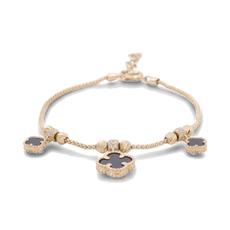 The Miral Jewelry 14K Gold Fashion Women's Onyx Flowers Bracelet, featuring dangling black clover-shaped charms, an adjustable clasp, and small decorative beads, is a stunning addition to women's fashion jewelry.