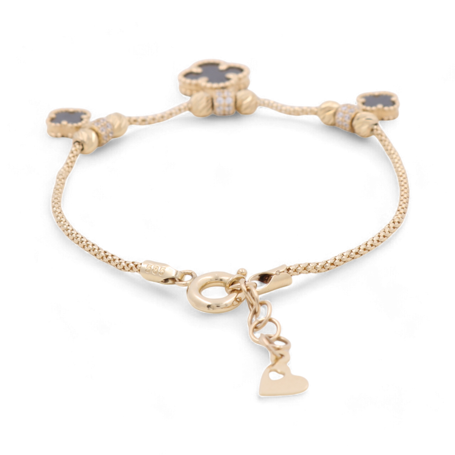 The 14K Gold Fashion Women's Fashion Onyx Flowers Bracelet by Miral Jewelry features four dark-colored clover-shaped onyx charms and a small dangling heart charm, making it a perfect addition to any women's fashion bracelet collection.