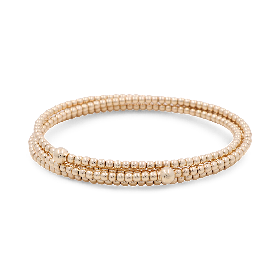 Introducing the Yellow Gold 14k Women's Fashion Bangle Bracelet by Miral Jewelry - a beautifully crafted piece featuring small, round beads strung together in three loops with a polished finish. This elegant 14k yellow gold bracelet is a stunning addition to any woman's fashion collection.