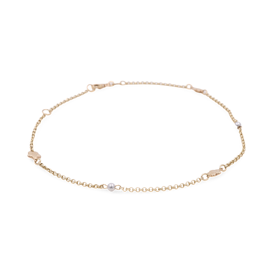 Close-up of a delicate Two Tone White and Yellow Gold 14k Women's Fashion Ankle Bracelet by Miral Jewelry, adorned with small beads and a clasp closure—a perfect fashion accessory.