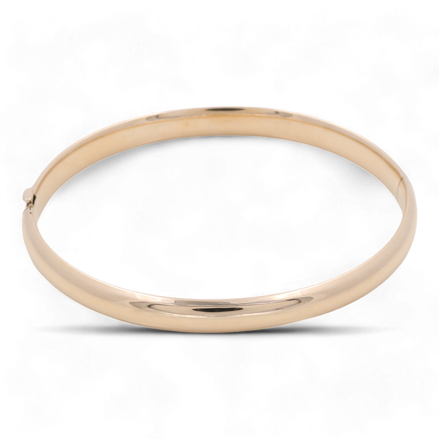 Miral Jewelry's 14K Yellow Gold Fashion Bangle is a simple, gold, circular bracelet crafted in 14K yellow gold with a smooth, polished finish that showcases high-quality craftsmanship.