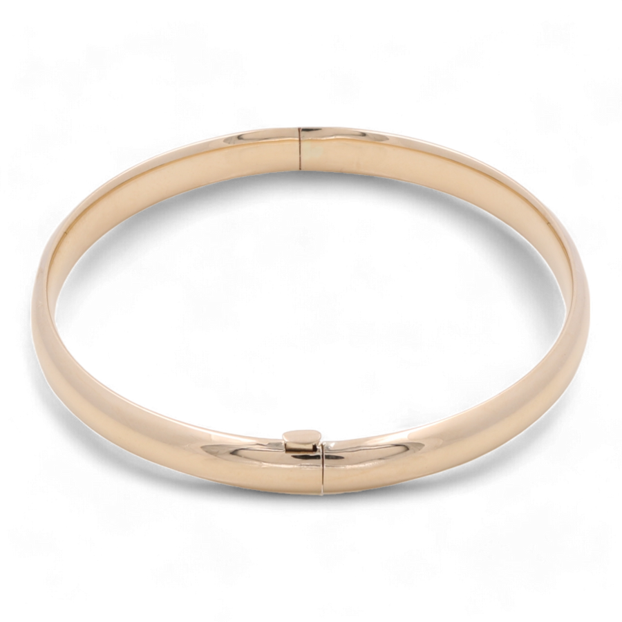 The Miral Jewelry 14K Yellow Gold Fashion Bangle, featuring a sophisticated plain design and a hinged clasp, makes for a timeless accessory.