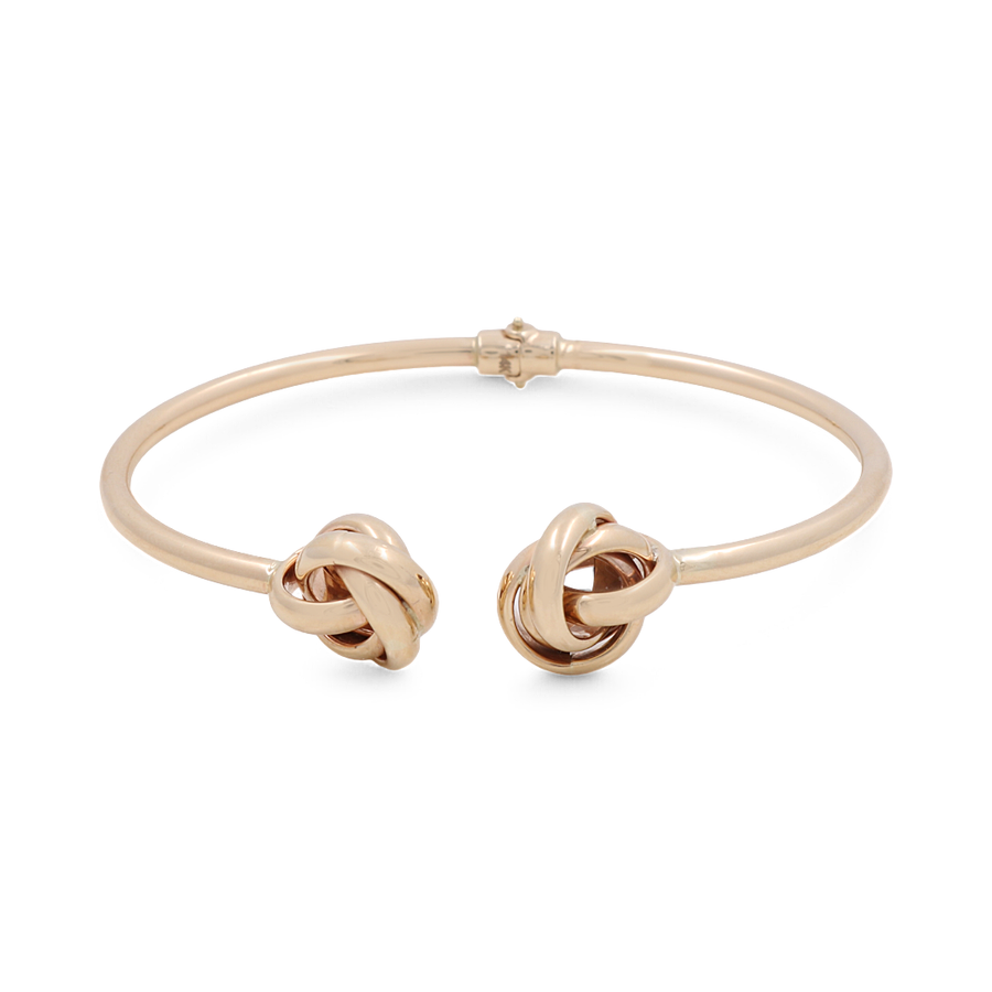 The Miral Jewelry 14K Yellow Gold Fashion Women's Bracelet is a chic addition to any woman's jewelry collection, showcasing two intertwined knot designs on each open end.