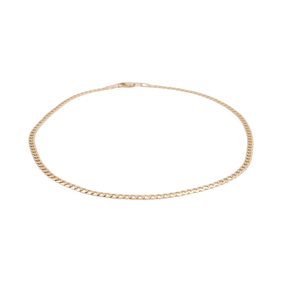 A delicate and timeless piece in women's fashion, the slim 14K Yellow Gold Women's Fashion Curb Link Ankle Bracelet from Miral Jewelry features a small clasp and is elegantly showcased on a plain white background.