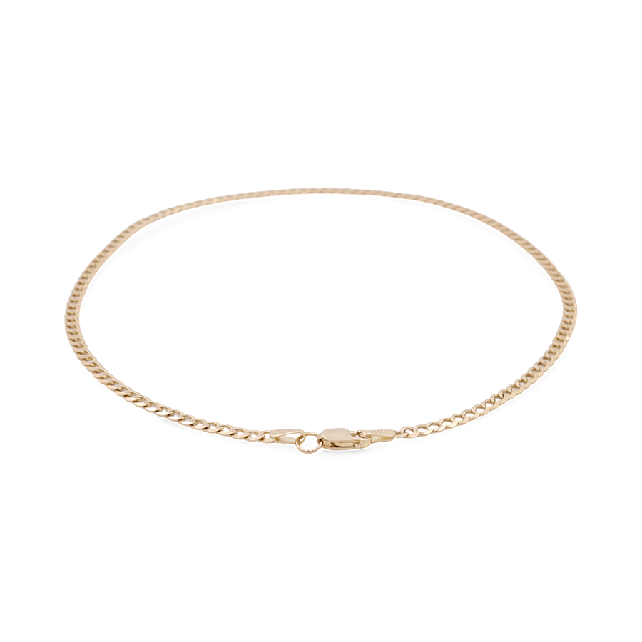 A delicate 14K yellow gold curb link ankle bracelet with a lobster clasp from Miral Jewelry lies in a circular formation, showcasing an elegant piece for women's fashion.