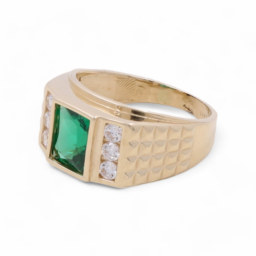 A Miral Jewelry 14K Yellow Gold Men's Emerald and Cubic Zirconias Ring with a large square green gemstone in the center, flanked by three small cubic zirconias on each side, and a textured design on its band.