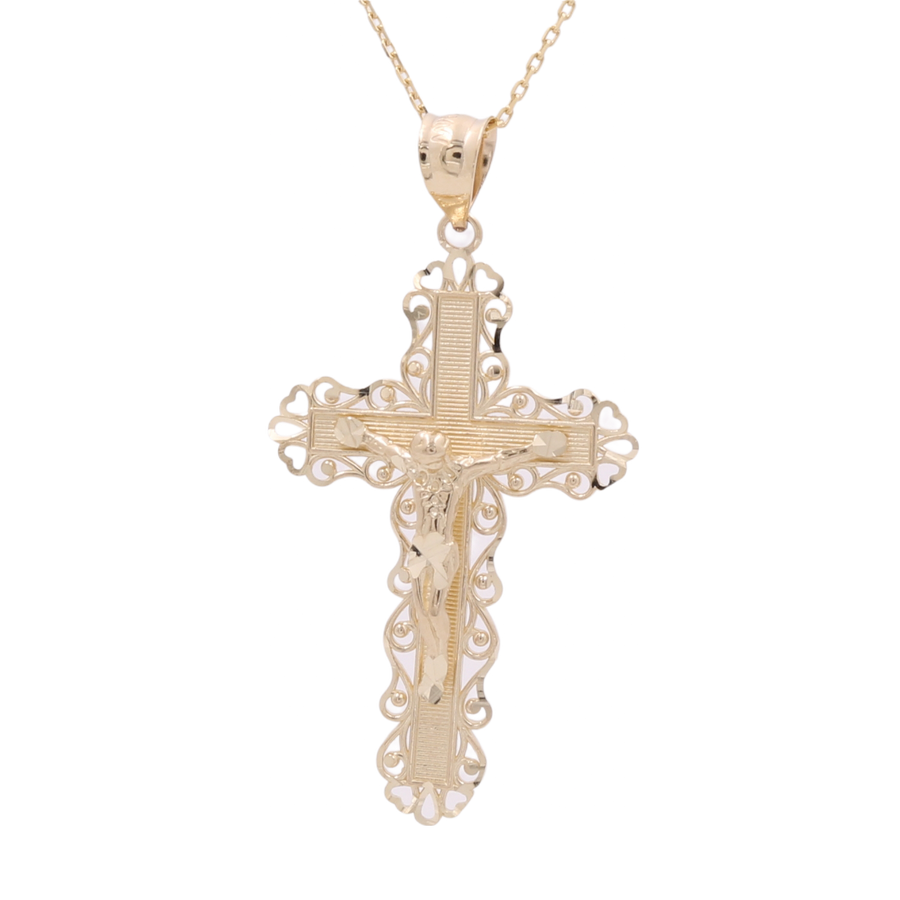 A 14K Yellow Gold Jesus Cross Pendant with intricate detailing hangs from a delicate 14K Yellow Gold chain, making it a stunning piece of statement jewelry by Miral Jewelry.