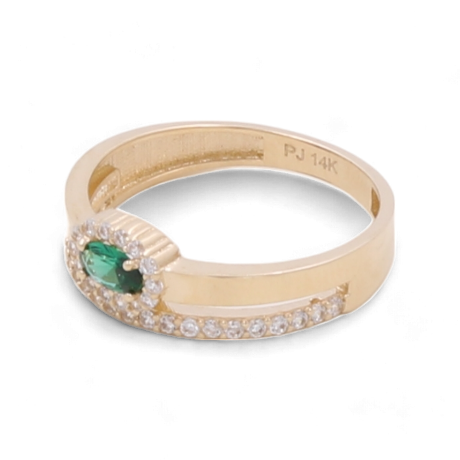 A 14K yellow gold ring from Miral Jewelry, featuring a small central green stone, surrounded by cubic zirconias, and additional diamonds on the band. The interior is engraved with "PJ 14K".