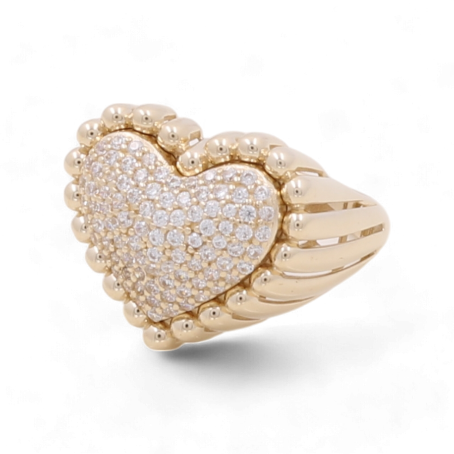 The 14K Yellow Gold Women's Heart Ring with Cubic Zirconias by Miral Jewelry features a heart-shaped design encrusted with small white stones.