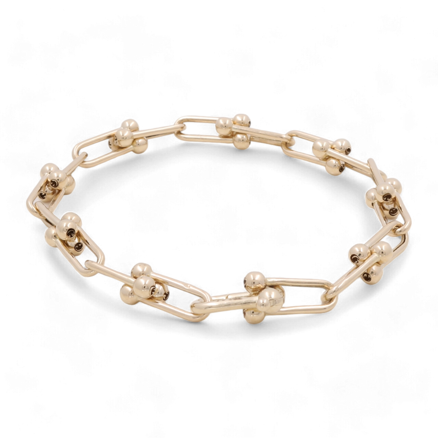 The 14K Yellow Gold Fashion Link Bracelet from Miral Jewelry exudes elegance with its angular links, each adorned with two small gold spheres. This fashion tennis bracelet is designed to dazzle, effortlessly blending sophistication and modern style.