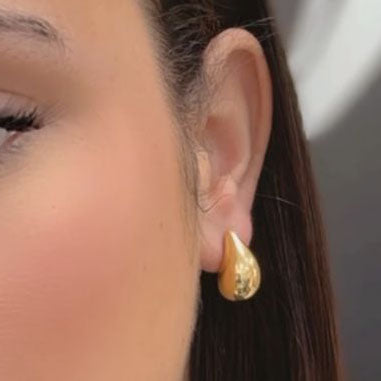 Close-up of a person's ear adorned with Miral Jewelry's elegant and luxurious 14K Yellow Gold Large Drop Earrings.